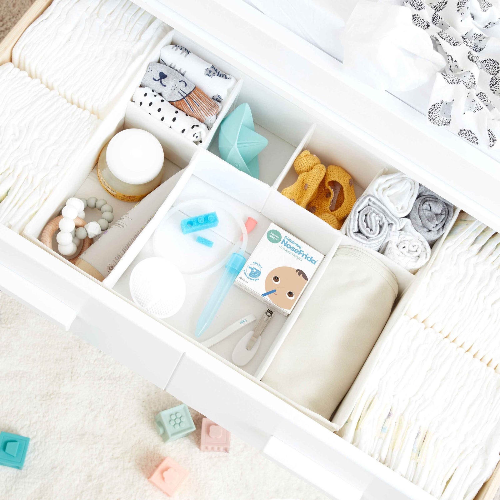 A nursery drawer neatly organised with nappies, clothes and baby care essentials.
