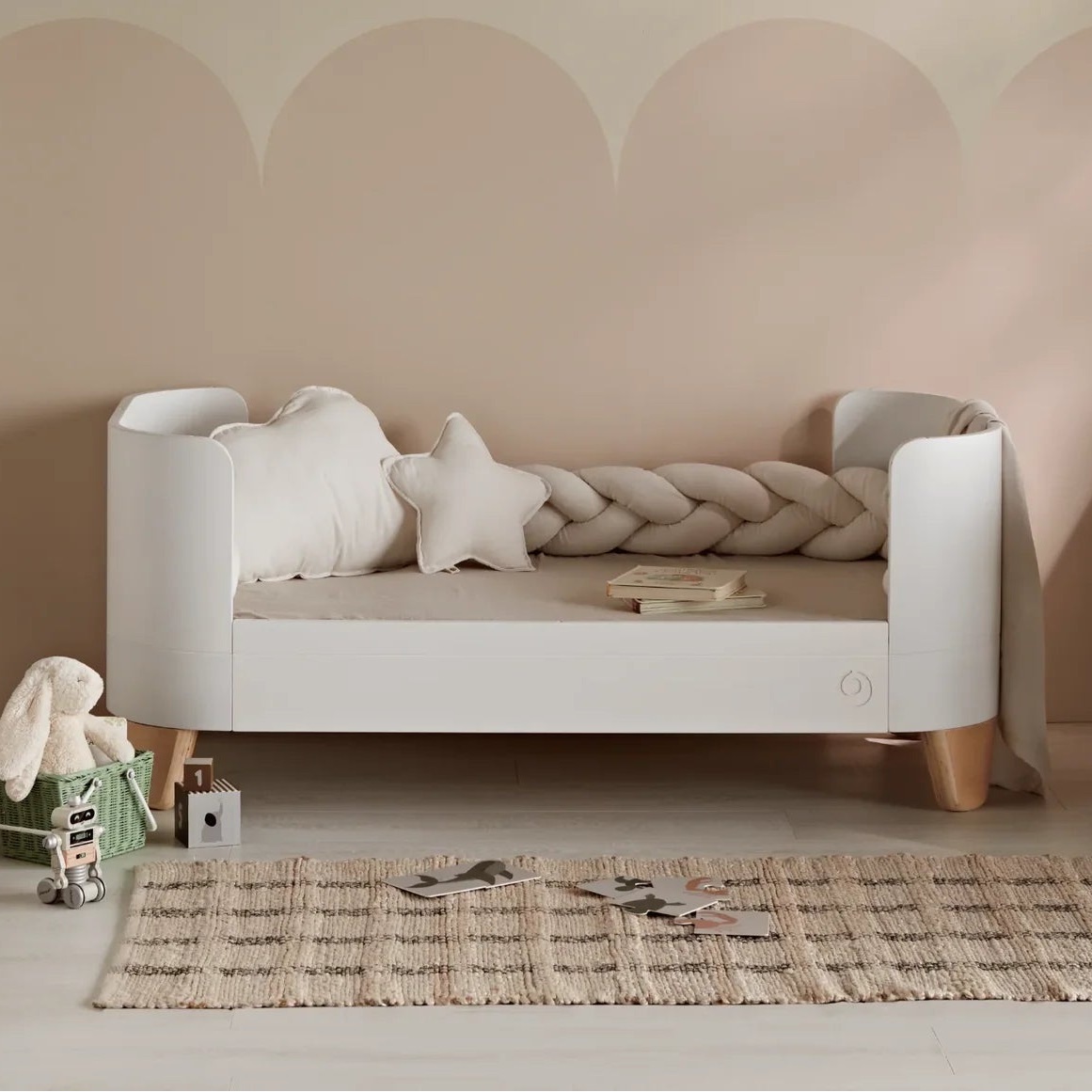 White Gaia Baby Serena cot bed with natural legs, converted to a first bed, in a softly styled child's room