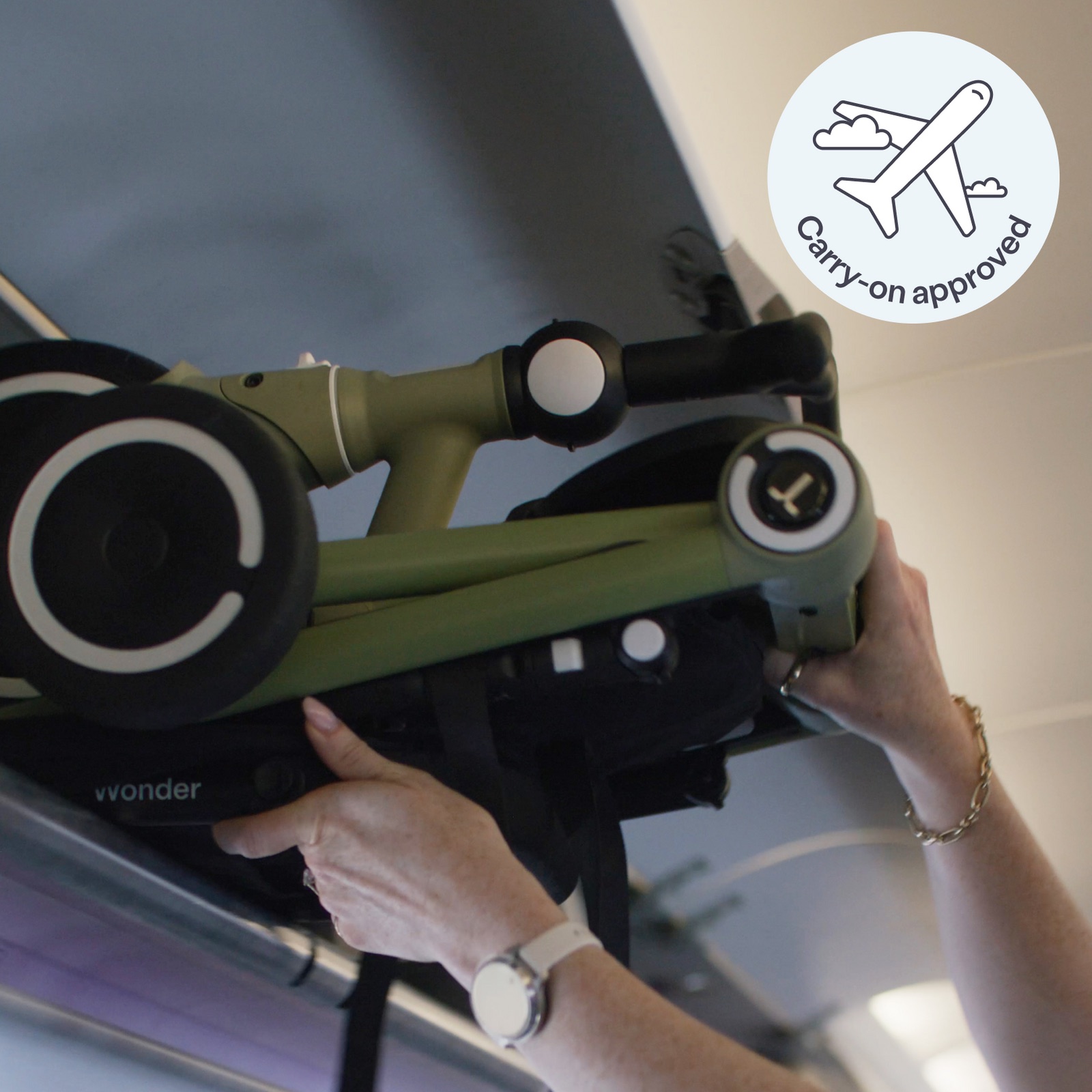A traveller lifts a folded smarTrike Wonder into an aircraft overhead locker.
