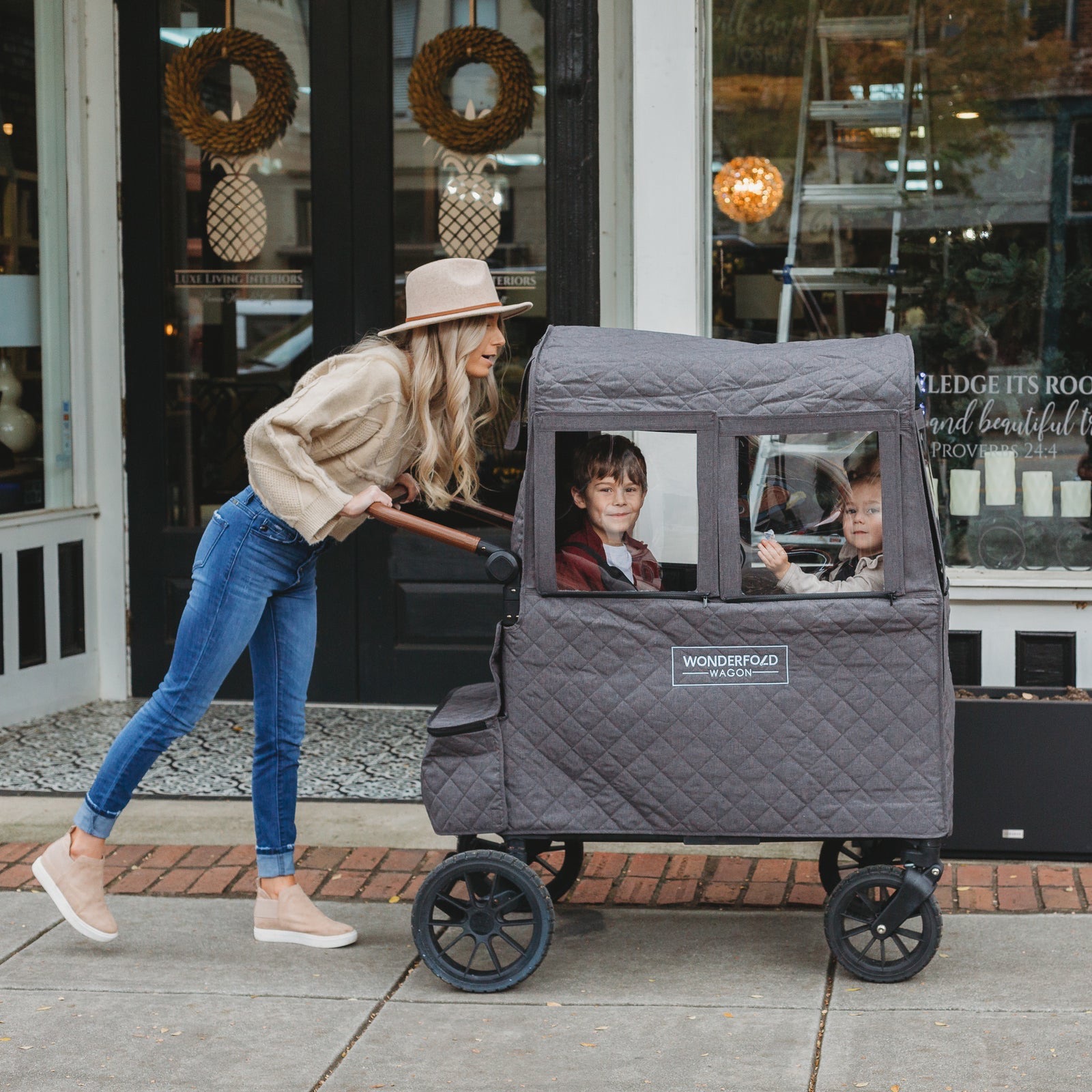 Parent pushing a WonderFold W2 fitted with the quilted Winter Cover along a footpath